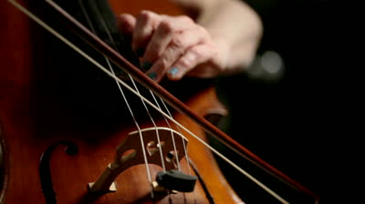 Stock footage detail footage of the hands of a cellist as she demonstrates both bowing and left hand fingering on